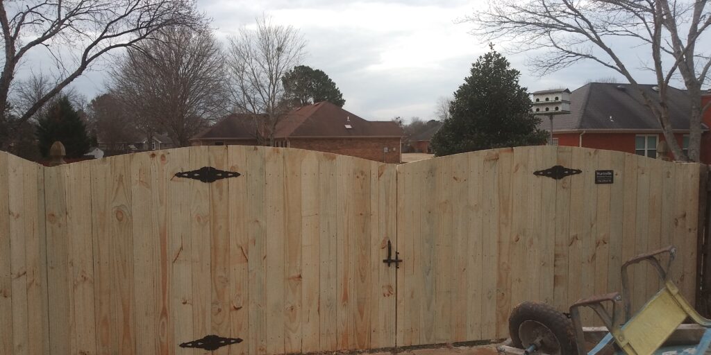 Six-foot cedar wood privacy fence with an arched gate in a Huntsville AL backyard